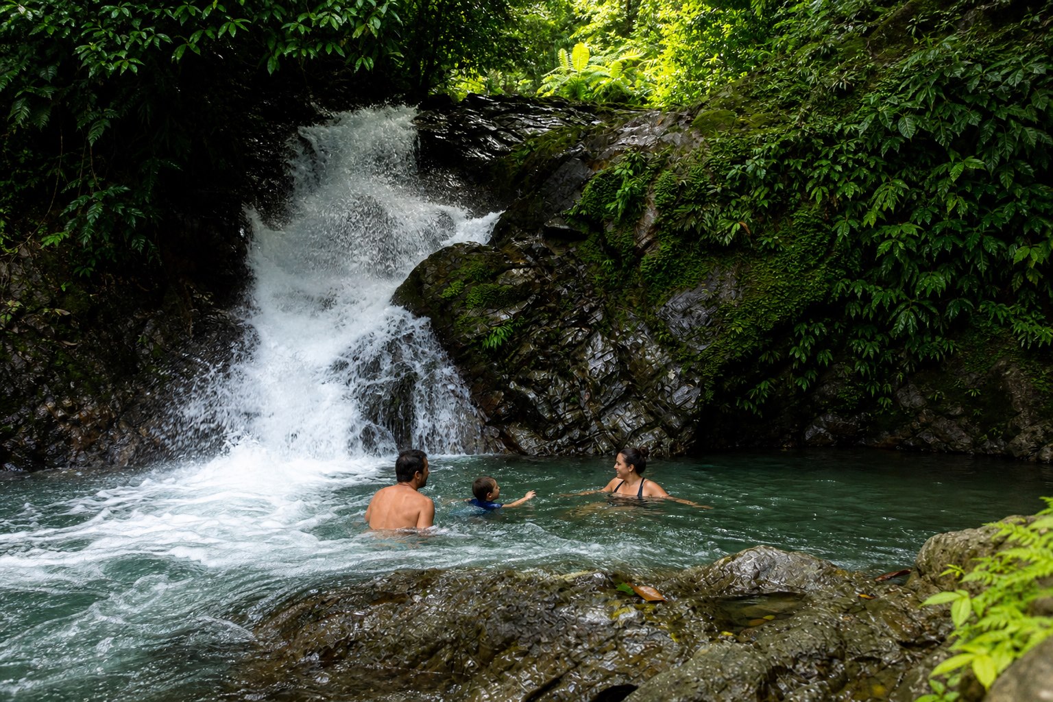 Family enjoying the waterfall pool visited on the horseback tour